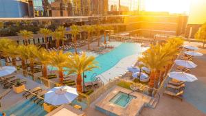 ラスベガスにあるHilton Club Elara Las Vegasのヤシの木と傘が並ぶプールの景色