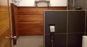 een badkamer met een toilet en een houten deur bij Beach Box Perhentian in Kampong Pasir Hantu