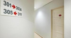 a white wall with a speed limit sign and a door at Swing & Pillows @ PJ KD in Sungai Way