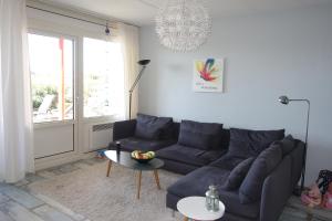 a living room with a blue couch and a table at Duinzicht in Buren