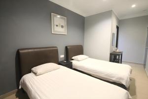 two beds in a hotel room with white sheets at Hotel Station 18 in Kampong Kuala Punti +146 photos