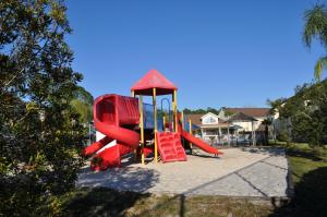 a playground with a red slide in a yard at Villas at Laguna Bay in Kissimmee