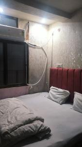 a bedroom with a bed with a red head board at Shlok homestay in Varanasi