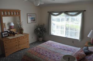 a bedroom with a bed and a dresser and a window at Villas at Laguna Bay in Kissimmee