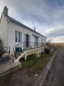 a white house with a bench on the side of it at Séjour vert au calme in La Machine