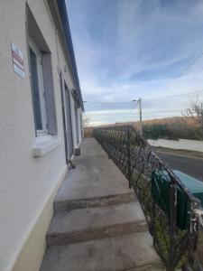 a stairway with a fence next to a building at Séjour vert au calme in La Machine
