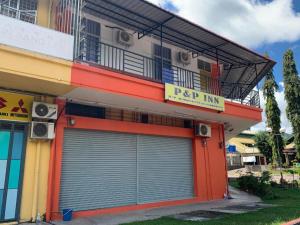 een gebouw met twee garagedeuren ervoor bij SPOT ON 89986 P&p Inn in Tambunan