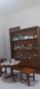 une table devant une étagère à livres avec de la nourriture dans l'établissement Homestay, à Labuan Bajo
