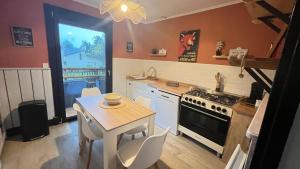 a kitchen with a table and a stove top oven at Les dunes le Lima in Quend-Plage