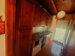 a small kitchen with wooden cabinets and a window at Locazione turistica Cuore d'Altopiano ad Asiago con ricarica per E-Bike in Asiago +10 photos