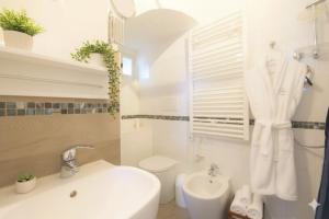 a white bathroom with a sink and a toilet at The Old Ship in Costarainera