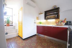 a kitchen with red cabinets and a yellow door at The Old Ship in Costarainera