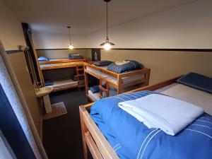 a room with two beds and a room with twounks at The Duke Hostel in Greymouth