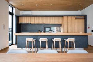una cucina con bancone e bar con sgabelli di V Residence by H2 Life a Niseko