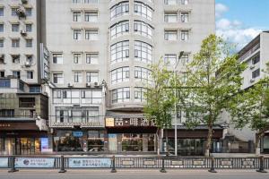 un gran edificio blanco con ventanas en una calle de la ciudad en James Joyce Coffetel·Hengyang Jiefang Road Xianfeng Dock, en Hengyang