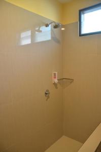 a bathroom with a shower with a glass door at Pondok Ganda in Ambarita +153 photos