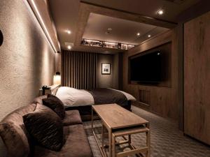 a hotel room with a bed and a couch and a tv at Y-HOTEL - Vacation STAY 22328v in Hiroshima
