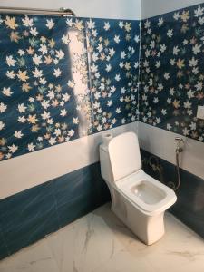 baño con aseo y pared azul en Kasauli Peak View Appartments, en Solan