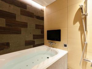 a bath tub in a bathroom with a tv on the wall at Y-HOTEL - Vacation STAY 22328v in Hiroshima +28 photos