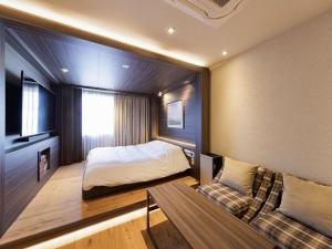 a bedroom with a bed and a couch at Y-HOTEL - Vacation STAY 22328v in Hiroshima