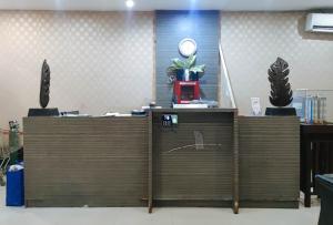 um cubículo de escritório com duas mesas e um relógio na parede em San Marino JY7 Rentals by RedDoorz em Cebu