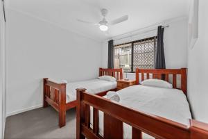 a bedroom with two beds and a window at Charming 3-Bed Home Near Sunshine Coast in Caloundra West