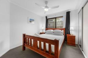 a bedroom with a large bed and a window at Charming 3-Bed Home Near Sunshine Coast in Caloundra West