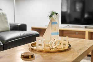 a wooden toy boat sitting on a coffee table at Charming 3-Bed Home Near Sunshine Coast in Caloundra West +14 photos
