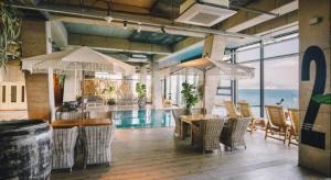 a restaurant with a pool and a table and chairs at Tropical Hideaway in Seogwipo