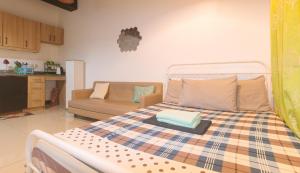 um quarto com uma cama e um sofá em San Marino JY7 Rentals by RedDoorz em Cebu