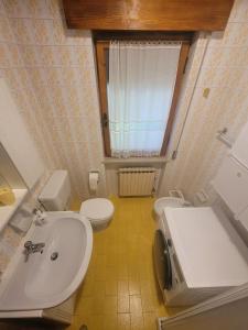 a bathroom with a white sink and a toilet at Cuore d'Altopiano, vivere Asiago in Asiago
