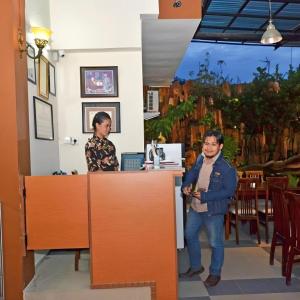 two people standing at a counter in a restaurant at Havilla Maranatha in Kampungdurian