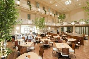 a restaurant with tables and chairs in a building at Air Terminal Hotel in Chitose