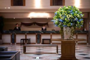 a large vase of flowers on a table in a lobby at Air Terminal Hotel in Chitose
