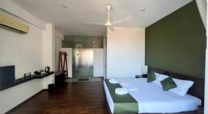 a bedroom with a large bed with a green wall at Lavinia Villa in Karagampitiya