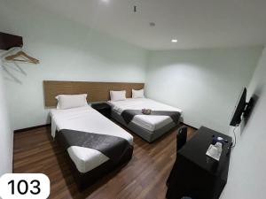 a hotel room with two beds and a television at Ezzyhome Taman Molek in Johor Bahru