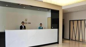 two men standing behind a white counter in a room at Jinjiang Inn Jinzhou Yunfei Bridge in Jinzhou