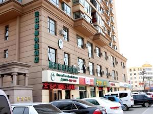 a large building with cars parked in front of it at GreenTree Inn Datong YundinGYAyuan Express Hotel in Datong