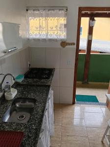 a kitchen with a sink and a counter top at Verde Mar Abricó 4 in Rio das Ostras