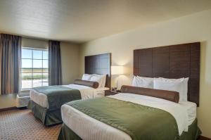 a hotel room with two beds and a window at Cobblestone Inn & Suites - Ord in Ord +55 photos