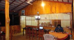 a person sitting at a table with a laptop at Inn On The Tree in Kibissa