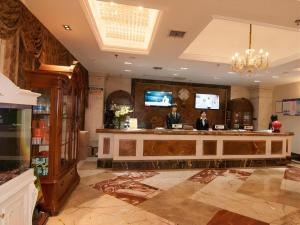 zwei Personen stehen an einer Bar in einer Hotellobby in der Unterkunft GreenTree Alliance Anhui Hefei South Passenger Station South High Speed Railway Station Hotel in Hefei