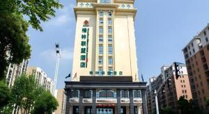 ein hohes Gebäude mit einem Turm darüber in der Unterkunft GreenTree Alliance Anhui Hefei South Passenger Station South High Speed Railway Station Hotel in Hefei