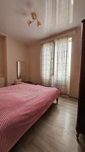 een slaapkamer met een groot bed met een rode deken bij Khatuna Home in Tskaltubo +9 foto's