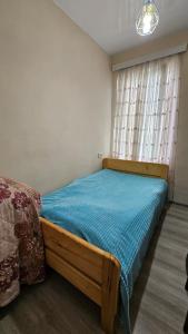 een slaapkamer met een houten bed en een raam bij Khatuna Home in Tskaltubo
