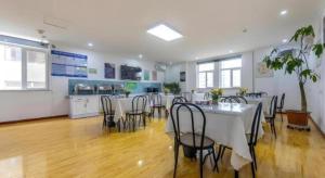 a room with tables and chairs and a kitchen at GreenTree Inn Lanzhou Gongjiawan Yangjiaqiao Express Hotel in Lanzhou