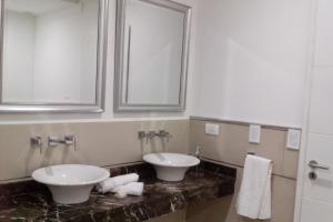 a bathroom with two sinks and a mirror at Pinamar Norte in Pinamar