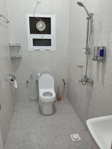 y baño con aseo, ventana y lavamanos. en ريف سناو للشقق الفندقية, en Distah