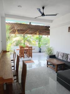 a living room with a couch and tables and chairs at Lakmali Homestay 2 in Weligama
