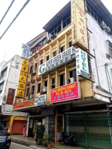 een gebouw met borden aan de zijkant bij SPOT ON 90625 Super Green Grass Hotel in Yong Peng